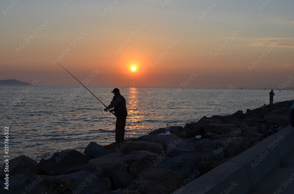 fishing sunset sea coast man