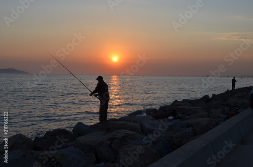 fishing sunset sea coast man