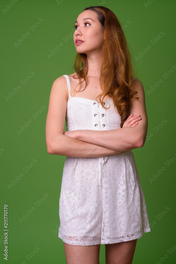 Young beautiful Asian woman against green background Young beautiful Asian woman against green background