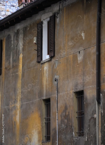 Old medieval street with crumbling facade of building.