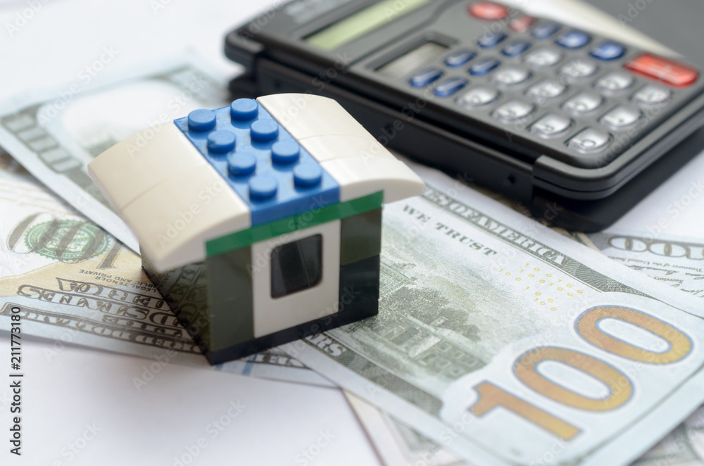 The concept of housing lending. Money, calculator, toy house. The concept of housing lending. Money, calculator, toy house.