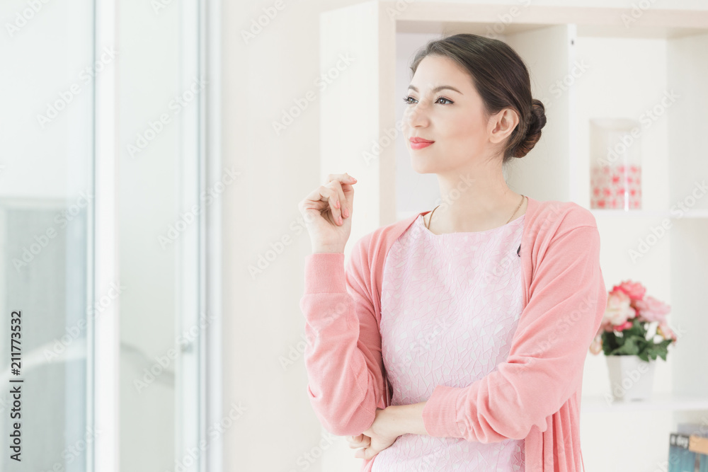 Business woman standing working near a window at home office. Business woman standing working near a window at home office.