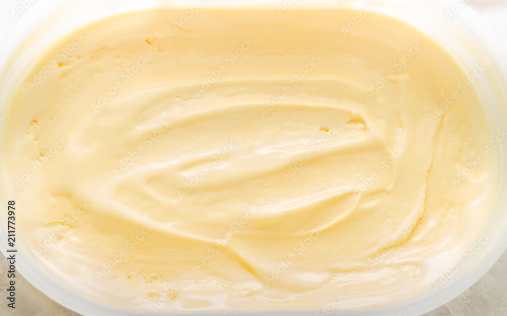 Ice cream of vanilla flavour half melting and freeze texture pattern background in white plastic bowl or box with ice cubes surrounding, summer sweet concept Ice cream of vanilla flavour half melting and freeze texture pattern background in white plastic bowl or box with ice cubes surrounding, summer sweet concept