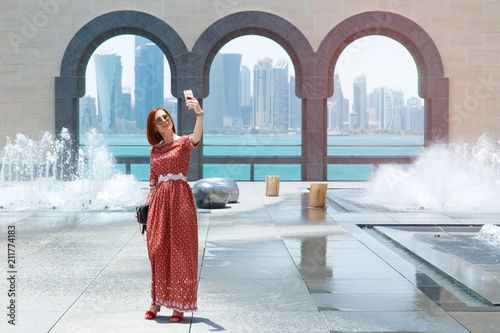 Girl opposite the skyscrapers and the sea in Doha.