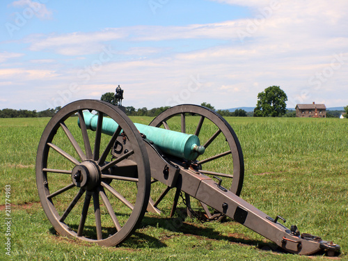 Civil war cannon with house and moument photo