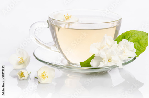 Glass cup of Tea with jasmine flowers and leaves