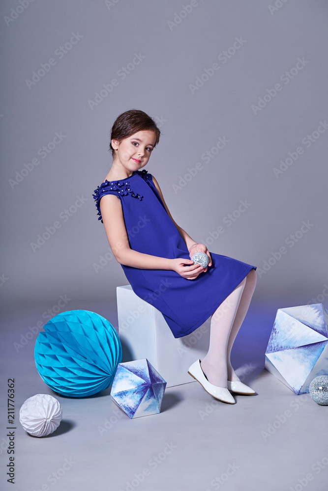Elegance Little Girl In Blue Dress For Teenagers Catalog Children S Clothes Stylish Little Lady Posing Sitting Studio Shot Gray Background Kid Model Creative Decorations Geometric Shapes Paper Stock Photo Adobe Stock