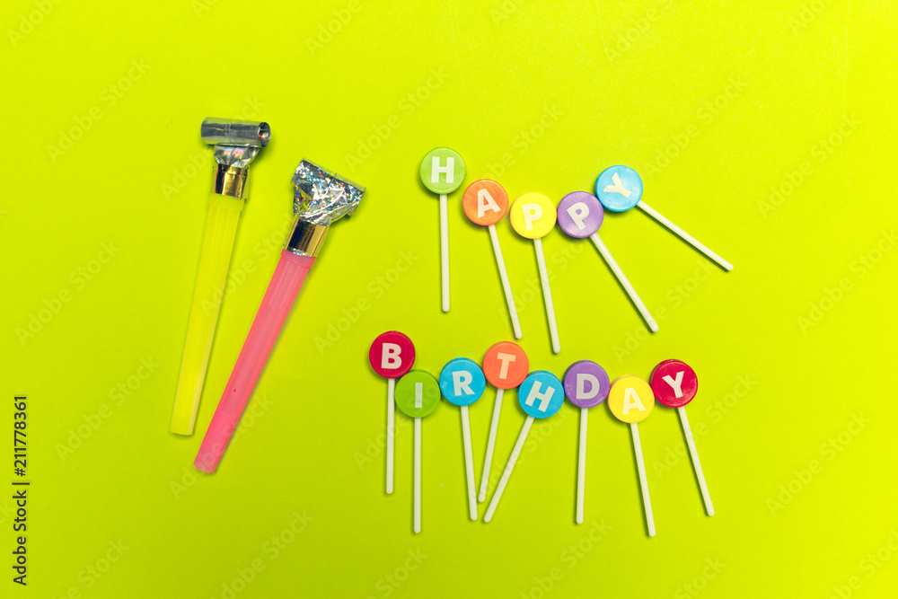 Colorful party blowers or noisemakers on colored background