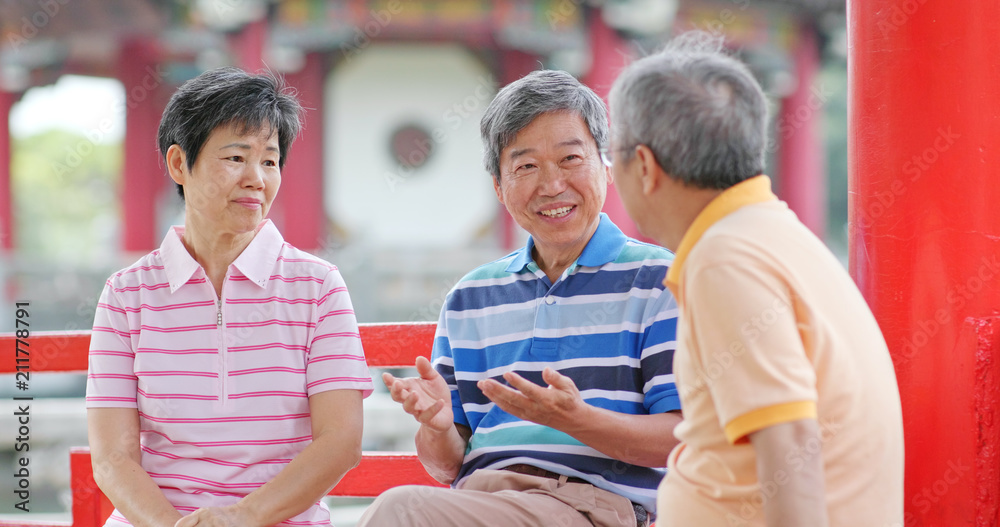 Obraz premium Elderly friends talk together at outdoor park