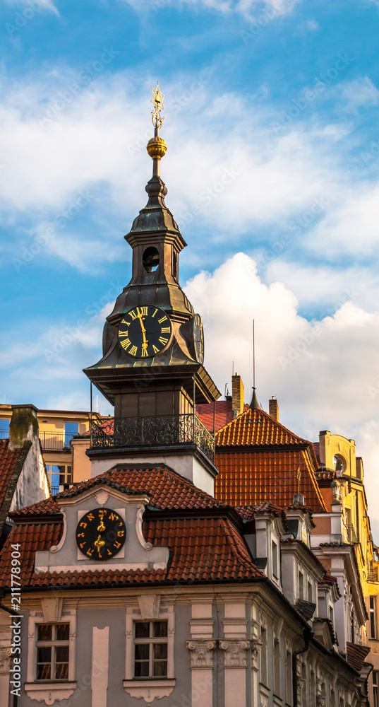 Fototapeta premium Clocks and spire with hebrew on the Jewish Town Hall in Josefov quarter of town. Tower and roof of High synagogue in Prague, Czech Republic