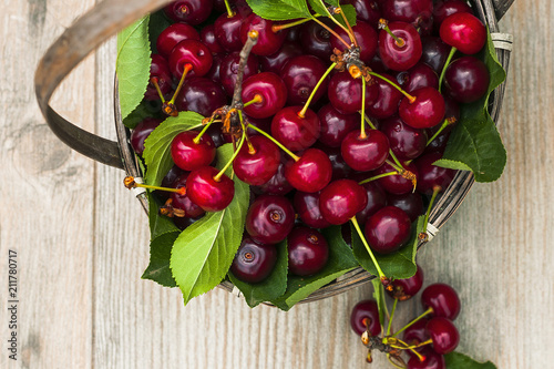 Juicy cherry, in a basket on a wooden table photo