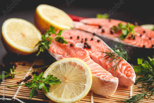 Salmon steaks with lemon and spices close up view.