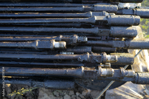Fototapeta Naklejka Na Ścianę i Meble -  Oil Drill pipe. Rusty drill pipes were drilled in the well section. Downhole drilling rig. Laying the pipe on the deck. View of the shell of drill pipes laid in courtyard. pump rod