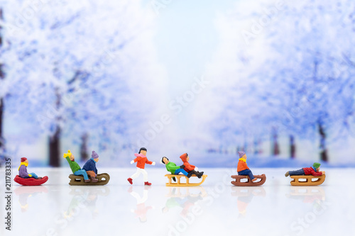 Miniature people: Children playing on snow funny together. Image use for Christmas festival