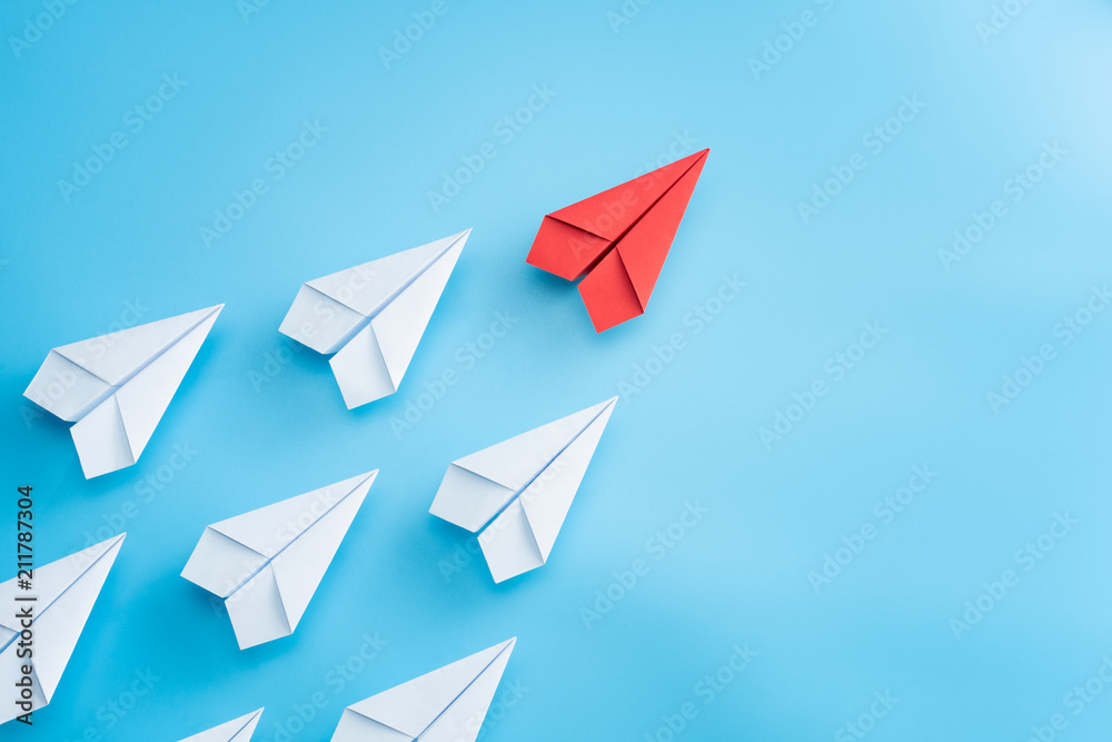 © Worawut - Leadership concept with red paper plane leading among white on blue background © Worawut - Leadership concept with red paper plane leading among white on blue background