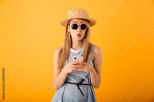Portrait of a surprised young blonde woman in summer hat