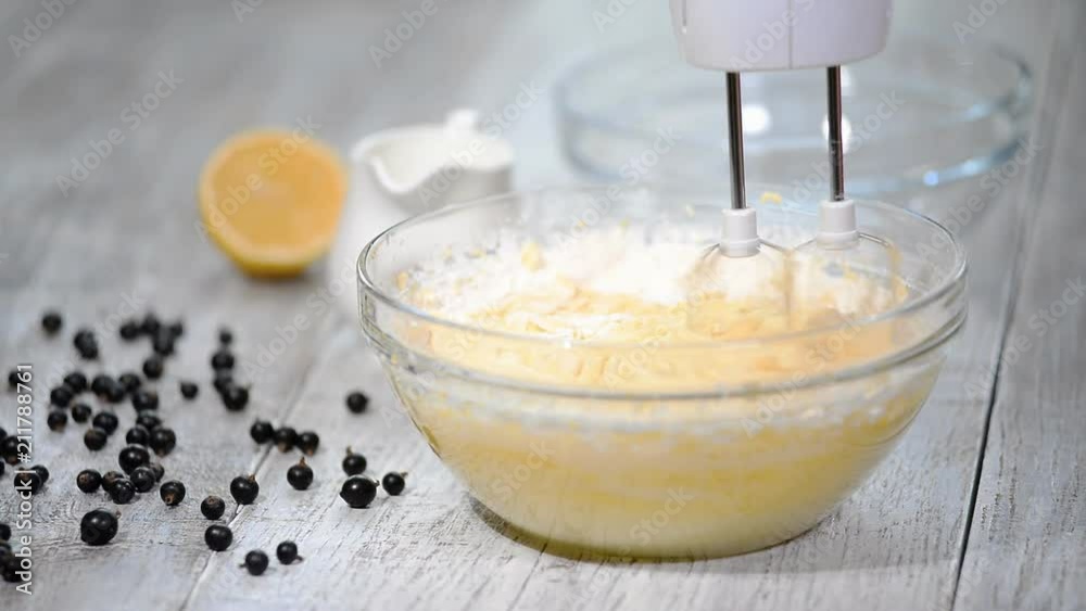 Female hands stirring dough with a mixer for cake. Female hands stirring dough with a mixer for cake.