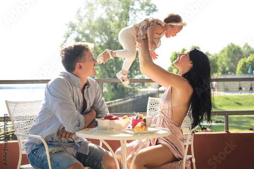 Lovely family sitting on a terrace, having breakfast