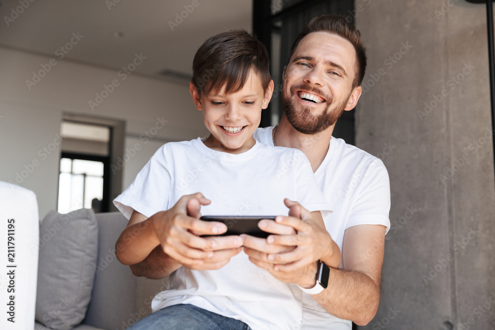 Handsome bearded man indoors at home with his son Handsome bearded man indoors at home with his son