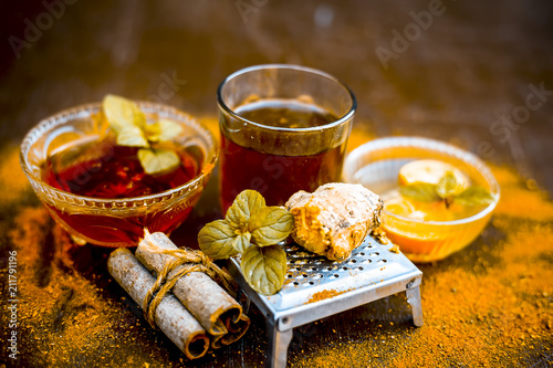 Принти на полотні Ancient ayurveidc home remedy for common cold: Grated ginger, warm water, cinnamon powder, honey, and lemon juice in a transparent glass on wooden surface