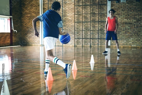 High school boys practicing football using cones for dribbling photo