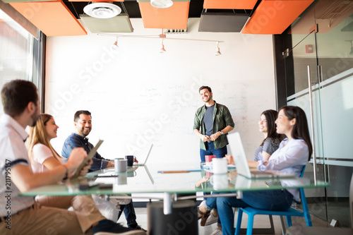 Young latin man giving presentation to his colleagues