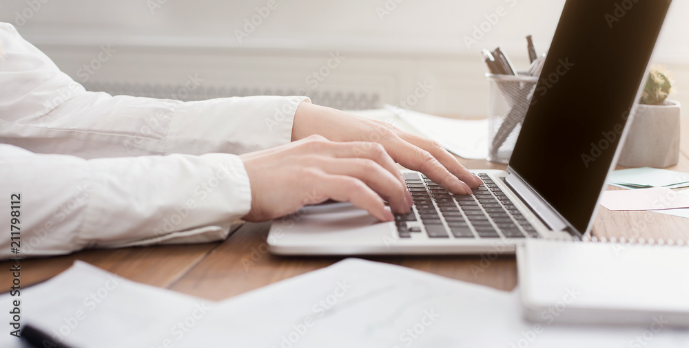 Side view of woman's hands typing on laptop keyboard Side view of woman's hands typing on laptop keyboard