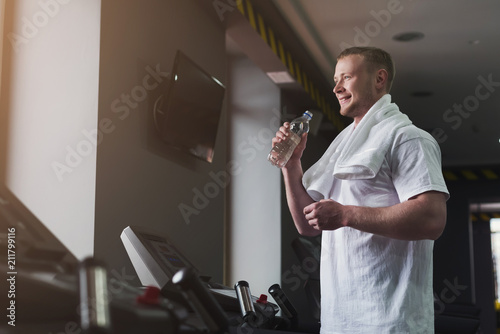 Male bodybuilder drinking water after workout photo