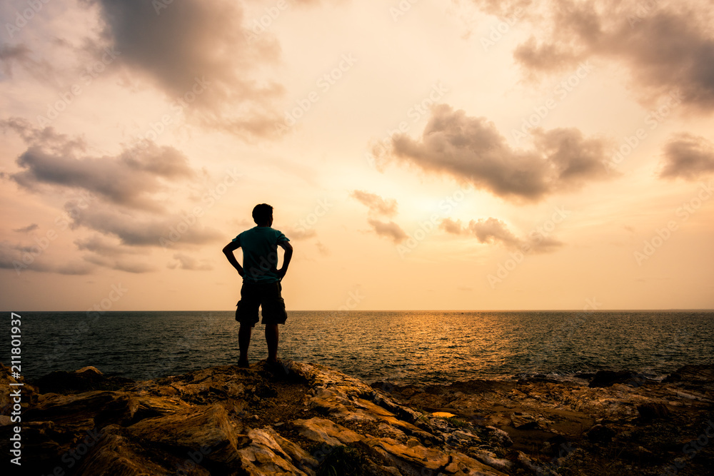 man standing on the rocks at the sea
