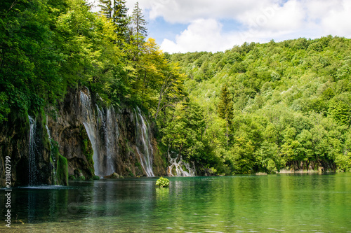 A large waterfall in the shade overlooking the rest of the natural reserve a beautiful set to contemplate. Photograph taken in the Plitvice Lakes, Croatia.