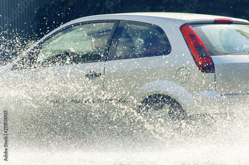 Fototapeta Naklejka Na Ścianę i Meble -  Car rain big puddle of water spray from the wheels
