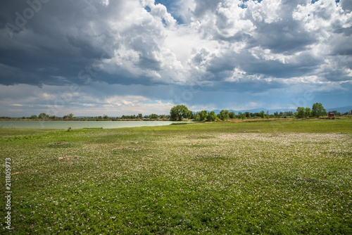 Storm clouds over a field of wildflowers near McIntosh Lake in Longmont, Colorado photo