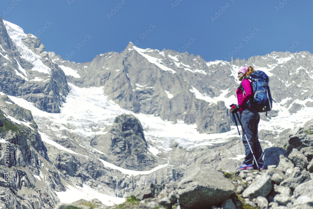 Trek around Mont Blanc. The girl is walking along the trail with a backpack.