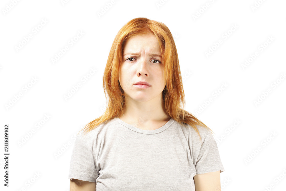 Close up portrait of redhead caucasian young woman, disappointed facial expression, whining with frowned eyebrows and miserable look. Pretty female with childish sad face. White background, close up. Close up portrait of redhead caucasian young woman, disappointed facial expression, whining with frowned eyebrows and miserable look. Pretty female with childish sad face. White background, close up.