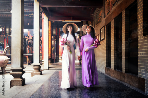 Vietnam woman wearing Ao Dai culture traditional at old temple at Ho Chi Minh in Vietnam,vintage style,travel and relaxing concept.