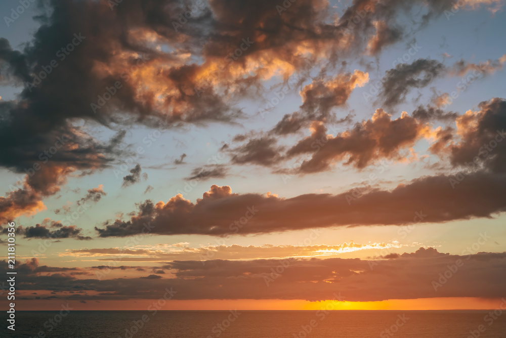 Obraz premium beautiful dramatic sunset over the sea with massive clouds. toned