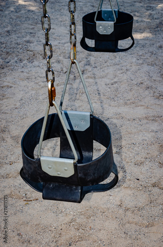 Two child bucket style swing seats on chains.