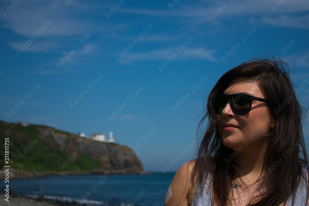 young woman with dark hair and sunglasses looking on beautiful landscape young woman with dark hair and sunglasses looking on beautiful landscape