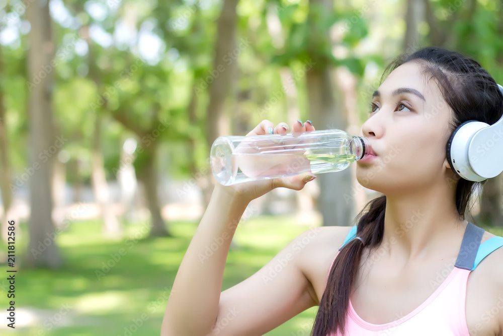 Asian young woman drinking water after workout exercising. Asian young woman drinking water after workout exercising.
