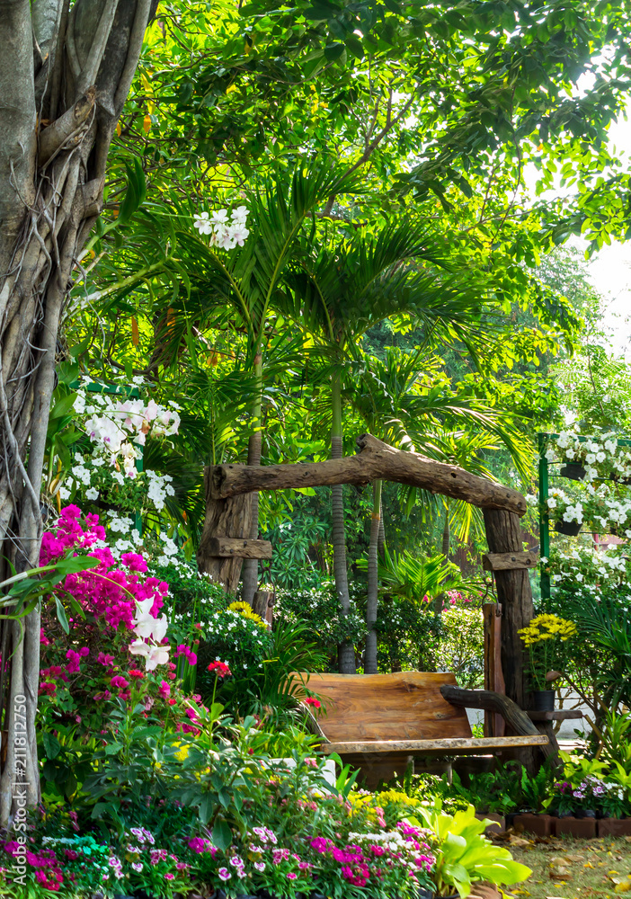 Wood chair in flowers garden./ Wood chair in cozy home flowers garden on summer.