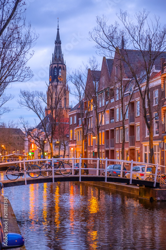 Evening view of the canal and the church in Delft. Dutch city in the spring after sunset. Holland, Netherlands.
