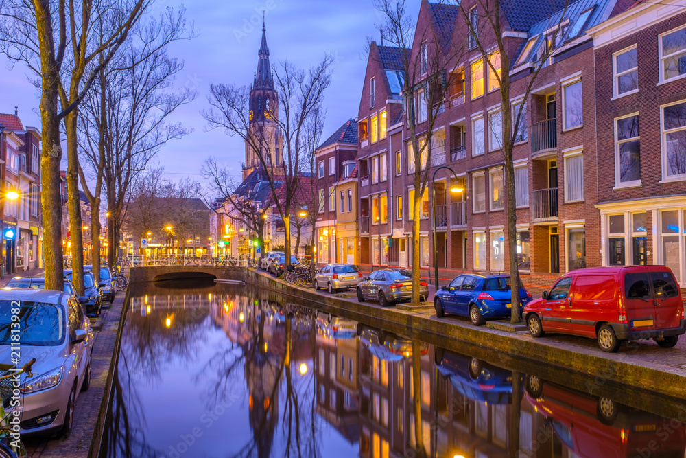 Evening view of the canal and the church in Delft. Dutch city in the spring after sunset. Holland, Netherlands.