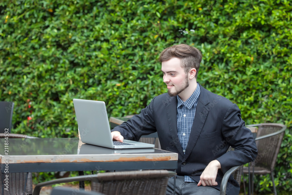 Portrait of young businessman using laptop in modern coffee shop outdoor Portrait of young businessman using laptop in modern coffee shop outdoor