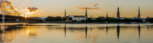 Panoramic view on historical district of old Riga city from left bank of the Daugava river, colorful sunrise