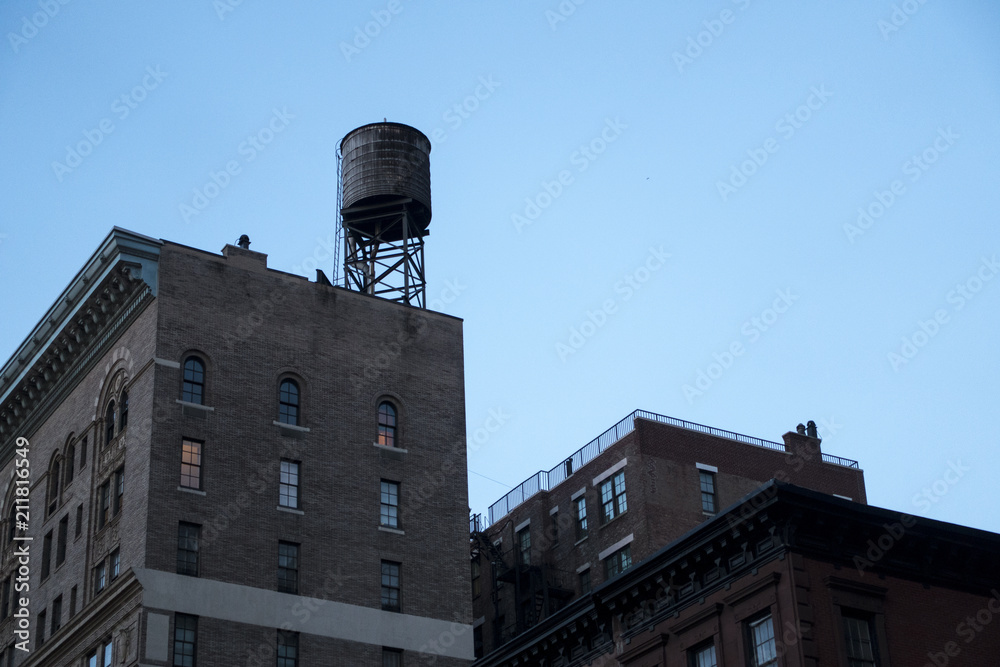 urban city buildings with classic rasied rooftop water-tower 