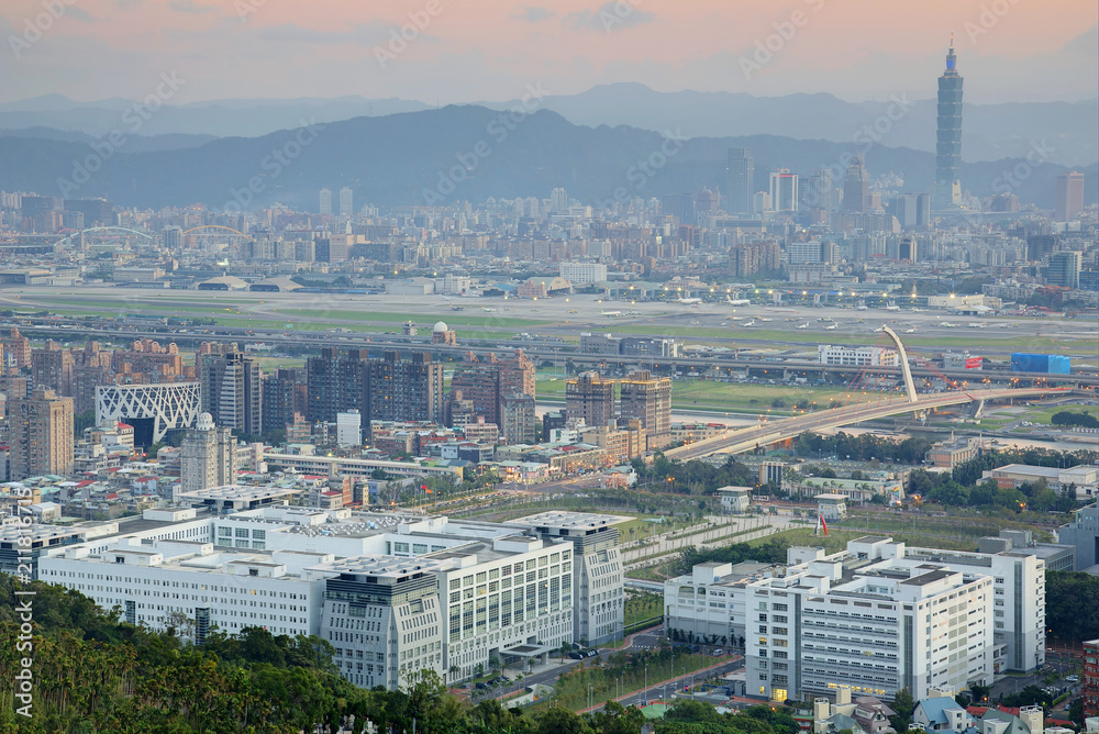 Aerial view of Taipei Songshan Airport and landmark  Tower amid skyscrapers in background, with heavily polluted air on a hazy day ( Air pollution level of PM2.5 classified as 