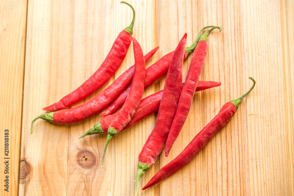 red hot chilly peppers on wooden table red hot chilly peppers on wooden table
