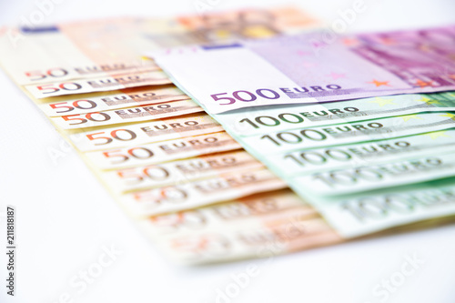 Euro banknotes close up. Several hundred euro banknotes on white background