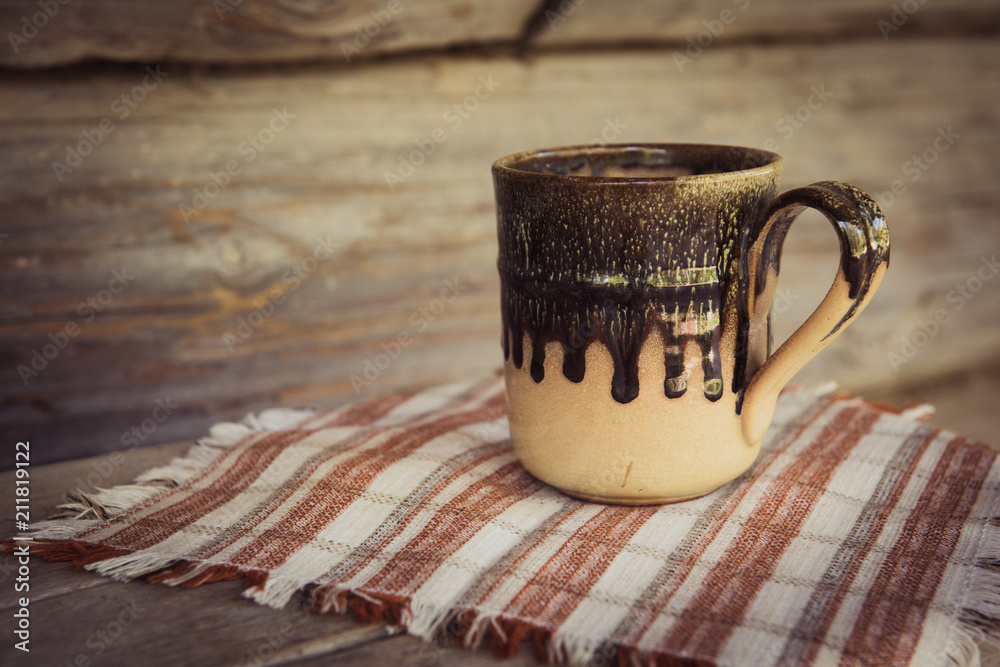 clay mug with a towel on a wooden bench clay mug with a towel on a wooden bench