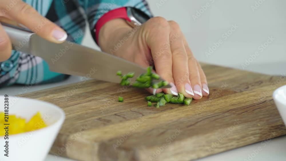 Woman's hands slicing sweet Bell Pepper on a wooden cutting Healthy food concept. Woman's hands slicing sweet Bell Pepper on a wooden cutting Healthy food concept.